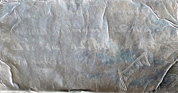 6.11.1956: Signierter Sinnspruch auf Silberfolie „Der Mensch handelt nach seinem Willen. Wie der Wille, so der Gedanke.“