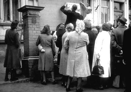 Erich Kuhlmann (links) und Egon Arthur Schmidt bringen die Informationstafel über das Heilverbot am Haus Wilhelmsplatz 7 an.